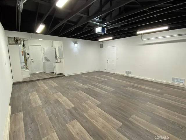 Completely Dreamy Remodeled Garage with Vinyl plank flooring, Sink and mirror and LED remote controlled light fixtures.