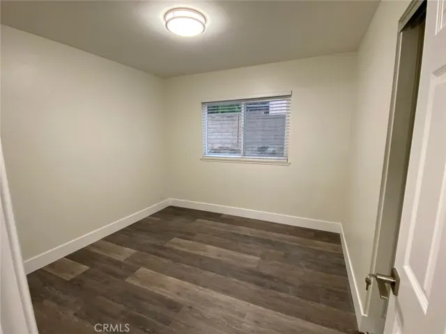 Bedroom #2 with LED light, Window covering, vinyl plank floors with baseboards and sliding closet door.