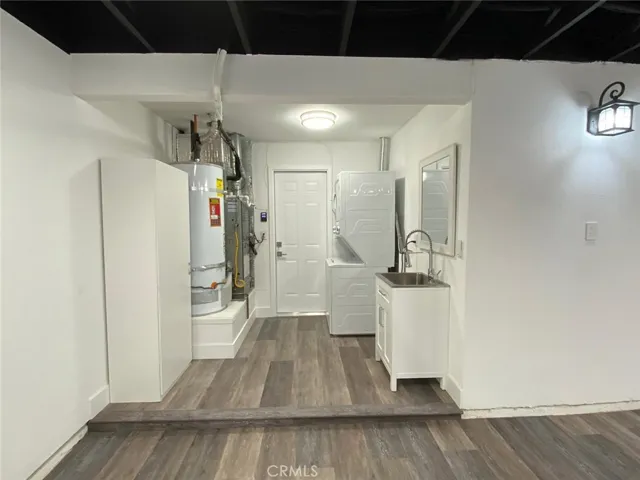 Sink and mirror and the stackable washer and dryer in the garage. Garage has Vinyl plank flooring.