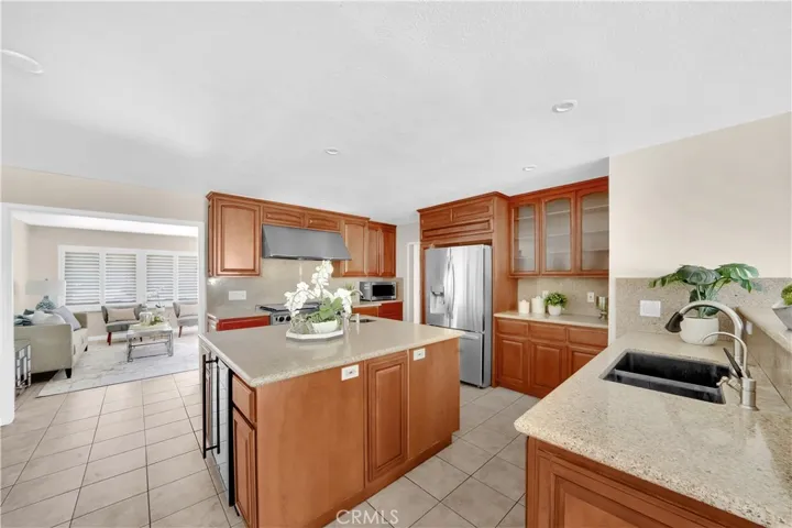 The gourmet chef's kitchen is a culinary dream, boasting a Viking 6-burner gas stove with griddle and dual ovens, granite countertops, and elegant cabinetry, some with glass fronts for display and buffet counters