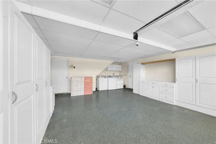 The finished garage includes epoxy flooring, custom cabinets, and a workbench.