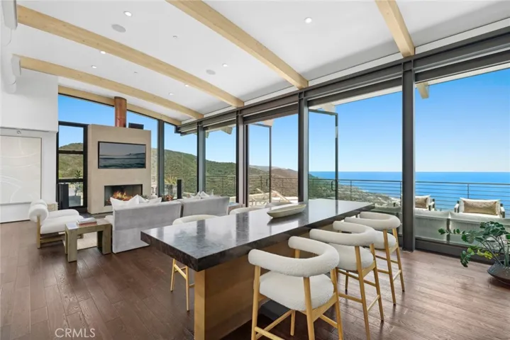 Seemingly above it all, with vistas that encompass colorful sunsets and ever-changing skies, the home is designed to erase the line between indoors and out, with floor-to-ceiling walls of glass that are mitered at corners.