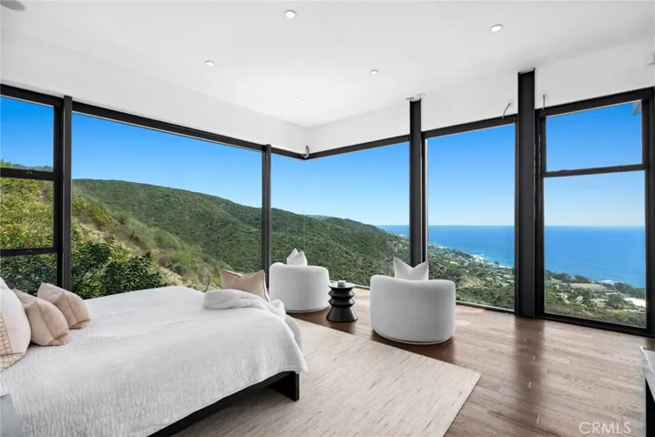 The primary suite, wrapped in walls of glass, appears to float above the sea.
