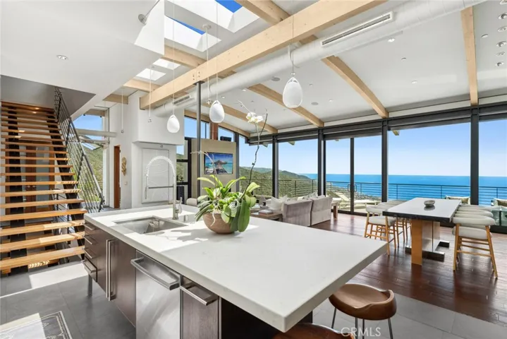  Top-tier appliances include a six-burner Wolf range and a built-in Sub-Zero refrigerator. High-end concrete, wood and stone finishes complement the home’s modern aesthetic, and a fabulous open staircase provides passage to the lower level.