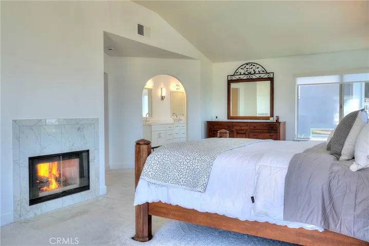 The Master Suite features Vaulted Ceilings, a cozy Fireplace surrounded by rich marble and plantation shutters for days when you want to sleep in