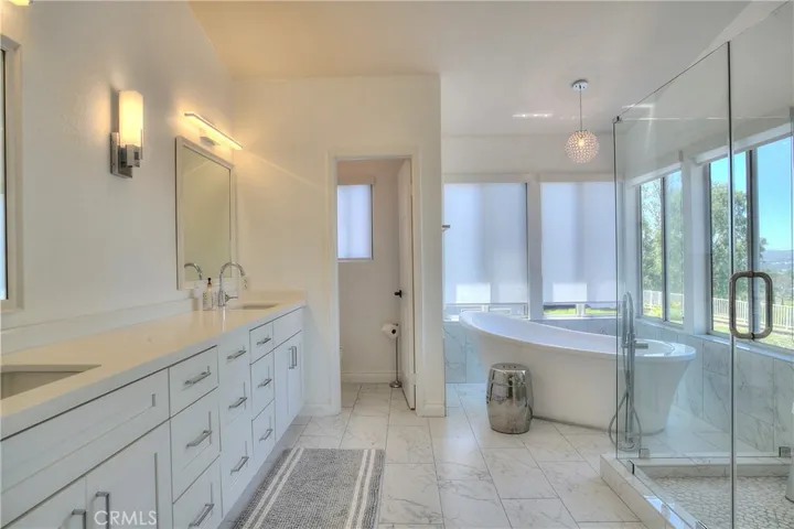 The primary bedroom boasts an ensuite bathroom with upgraded counters, a walk-in shower, and tiled walls, providing a luxurious retreat.