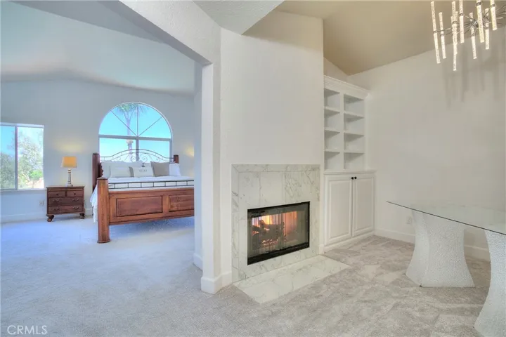 The spacious Master Suite with dual walk-in closets, dual-sided fireplace, retreat, double-door entry and high ceilings