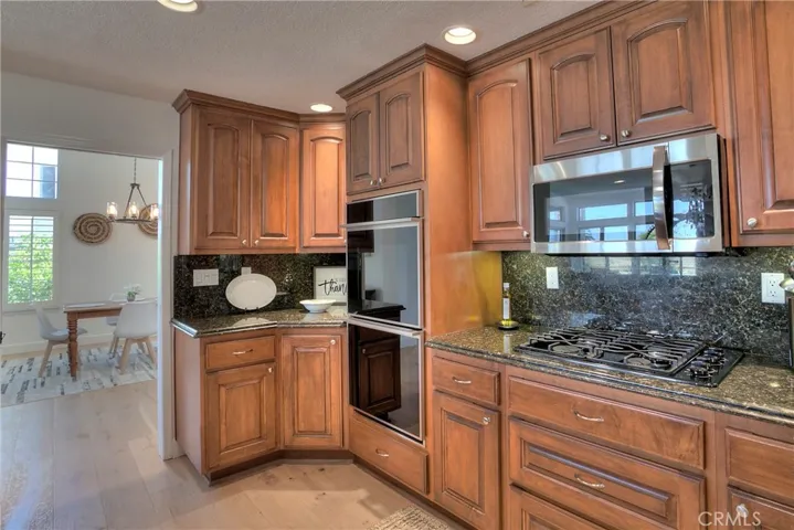 Granite countertops and beautiful wood cabinets enhance this spacious Kitchen layout