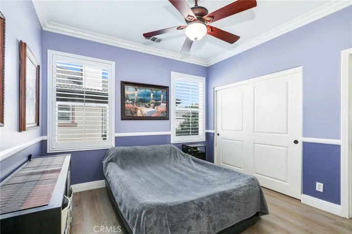 4rth bedroom with ceiling fan and track door closet with built- in organizer.