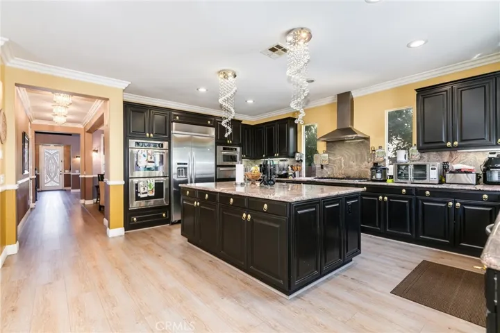 KitchenAid brand appliances: Double convection oven, Refrigerator, microwave, food warmer, big range hood, granite countertop bullnose edges with full back splash all-around the wall