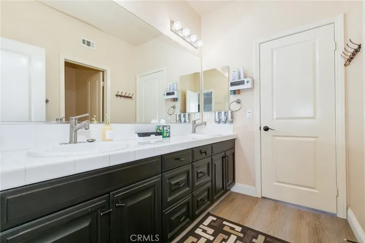 Attached bath with fifth bedroom, remodeled with double sink, vanity fixtures and toilet