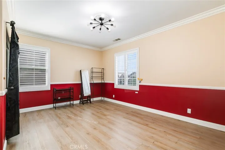 5th bedroom with chandelier and track door closet with built-in organizer and beautiful chair rail wit red border
