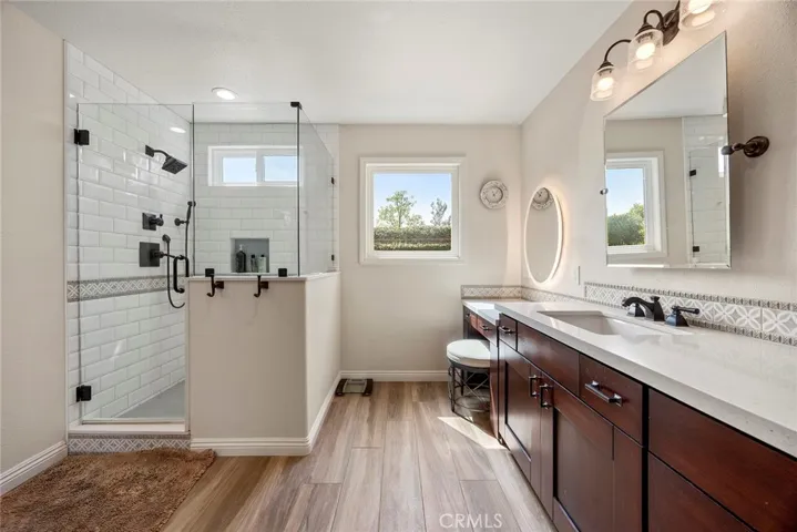 Freshly remodeled primary bath has spacious walk-in shower with glass enclosure. Dual vanity sinks with quartz counters mean there is plenty of space for getting ready in the morning.