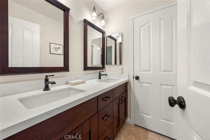 Hall bath has been completely remodeled with dual vanity sinks, light fixtures, quartz counters, new flooring.