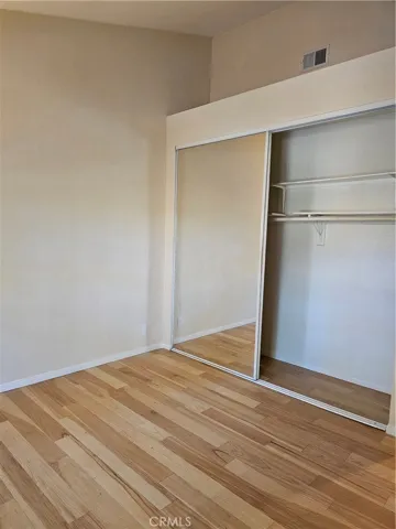 Secondary bedroom from another angle, with mirrored closet doors.