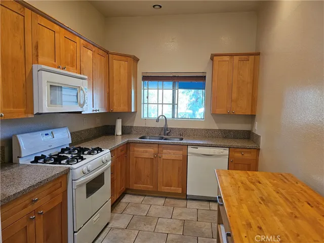 Open kitchen floor plan with upgraded Quartz countertops and nice cabinetry, built-in microwave, dishwasher and gas stove. Mobile kitchen island is included.