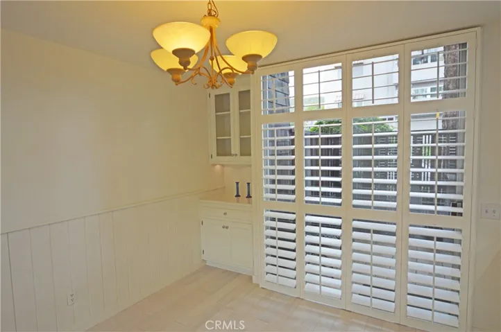 The wood shutters can be folded aside to open the tall glass sliding doors to the patio.