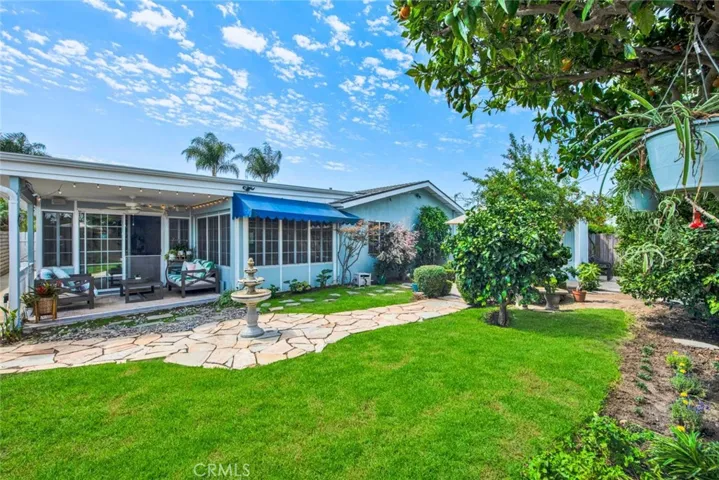 Large Private Backyard is Truly a Tranquil Sanctuary from the Outside World with its Lush Foliage, Fountain, Covered Patio, Awning, Flagstones, Lawn, Brick-Accented Decking, Vegetable Garden Area, Custom-Built Shed that Matches the House, 2 Additional Secluded Patio Areas, and Multiple Fruit Trees - Avocado, Pomegranate, 2 Orange, Lemon, Limon, Grapefruit, and Apple.