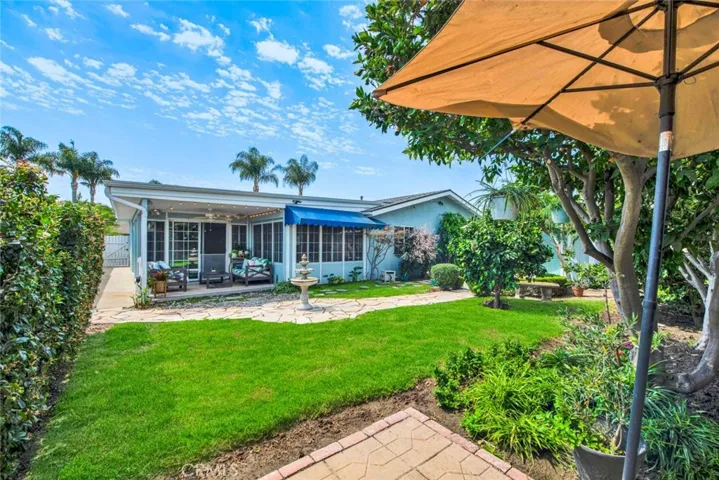Large Private Backyard is Truly a Tranquil Sanctuary from the Outside World with its Lush Foliage, Fountain, Covered Patio, Awning, Flagstones, Lawn, Brick-Accented Decking, Vegetable Garden Area, Custom-Built Shed that Matches the House, 2 Additional Secluded Patio Areas, and Multiple Fruit Trees - Avocado, Pomegranate, 2 Orange, Lemon, Limon, Grapefruit, and Apple.