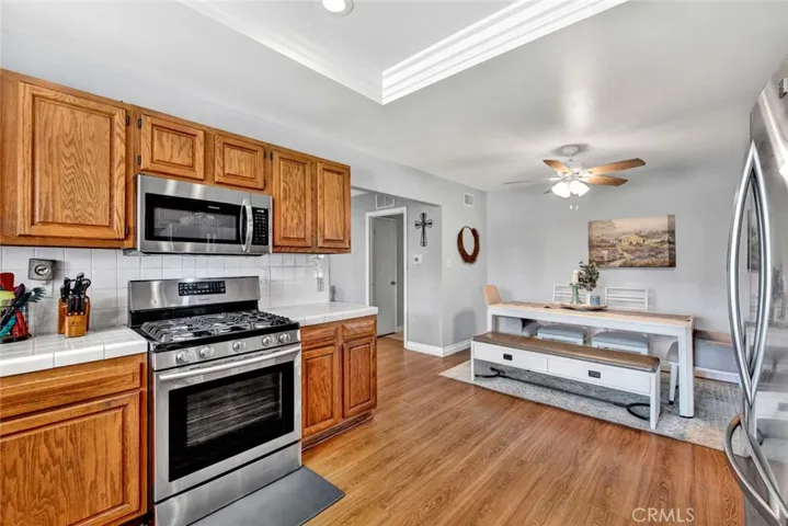 The Kitchen is Open to a Spacious Dining Room with a Ceiling Fan.