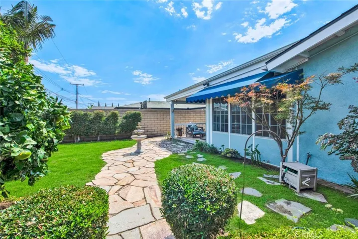 Large Private Backyard is Truly a Tranquil Sanctuary from the Outside World with its Lush Foliage, Fountain, Covered Patio, Awning, Flagstones, Lawn, Brick-Accented Decking, Vegetable Garden Area, Custom-Built Shed that Matches the House, 2 Additional Secluded Patio Areas, and Multiple Fruit Trees - Avocado, Pomegranate, 2 Orange, Lemon, Limon, Grapefruit, and Apple.