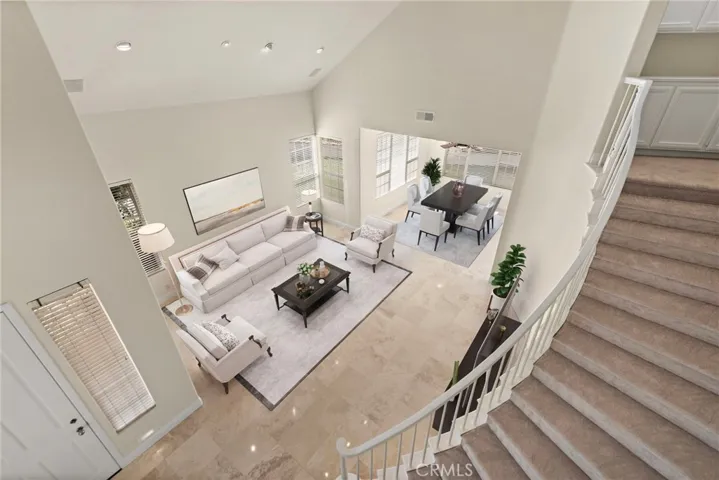 Looking down from the beautiful staircase you can see the natural flow between living and dining areas (virtual staging)