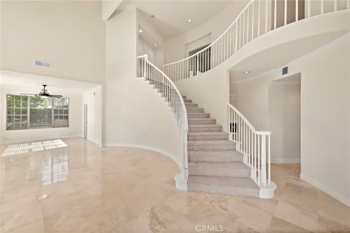 The first things you notice when step into this home are the soaring ceilings, beautiful staircase and luxurious travertine floors