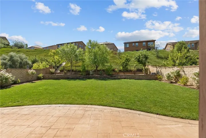 backyard with paved patio and lush landscaping including a vegetable garden