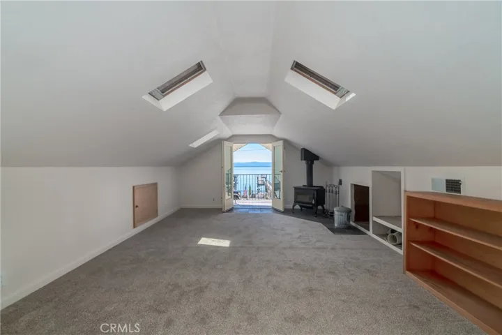Upstairs bedroom with wood burning stove and deck overlooking the lake.
