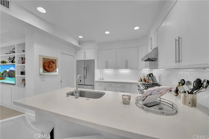 Bright light & open kitchen features stone & stainless steel appliances