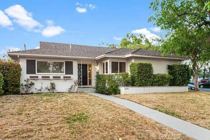 The front lawn, raised flowerbeds, well-trimmed hedges, mature shade tee and covered entryway enhance its eye-catching curb appeal.
