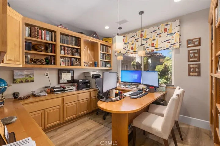 Office with closet and expansive built-in desk and cabinets.