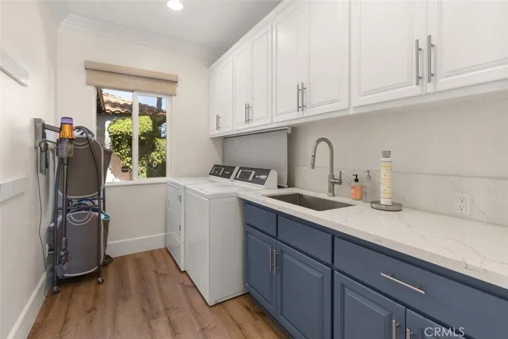 Large laundry room with natural light, stylish cabinets and quartz countertops.