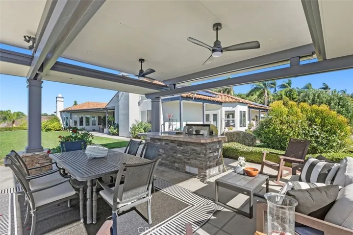 Large pergola with built-in barbecue and two fans.