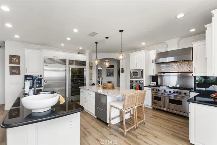 Kitchen with stylish granite countertops and backsplash, elegant lighting fixtures and professional grade appliances.
