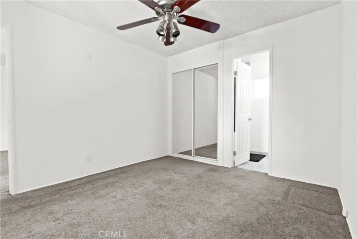 Primary bedroom with mirrored closet and bathroom