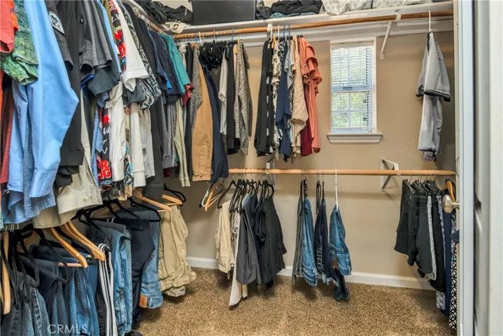 Oversized walk in closet with organizers and window