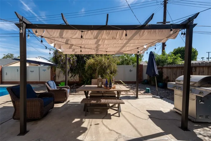 This inviting sitting area features a spacious patio, ideal for alfresco dining or morning coffee, surrounded by lush landscaping that adds privacy and charm.
