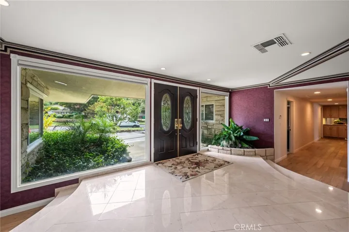 Grand entrance with marble tile floors and large picture windows.