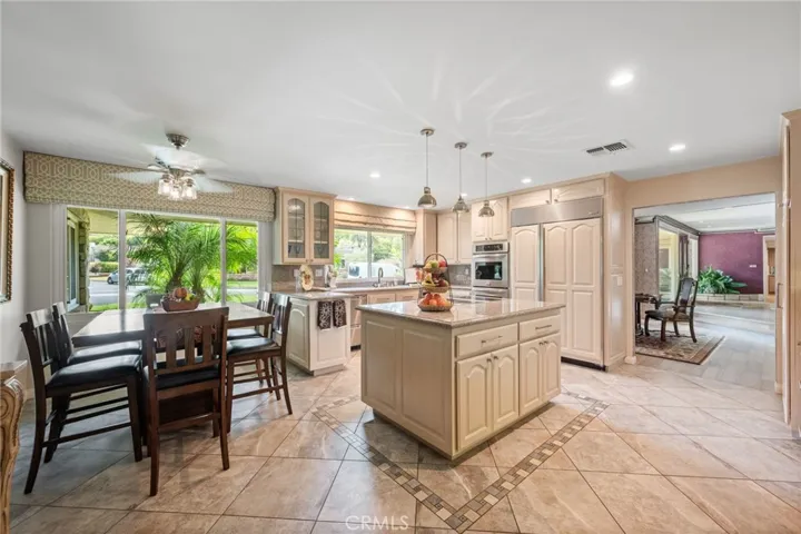 This is the perfect spacious kitchen, with a dining area, a center island, tons of counter space and a pantry and desk area just out of sight on the right of this photo.