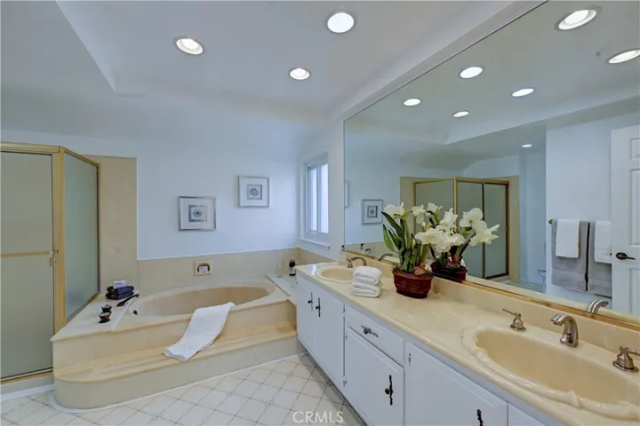 Large primary bath with dual sinks, recessed lighting and a window.