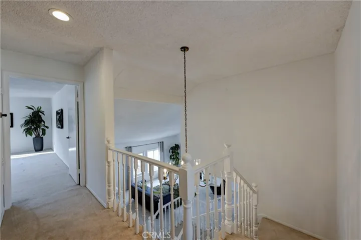 Your view from the top of the stairs to the downstairs formal living room and down the hall to the bonus room upstairs.
