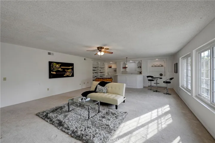 Enormous bonus room with wet bar, extra large wine rack, cabinetry for games, lighted ceiling fan and lots of natural light.