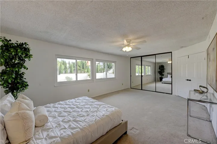 Primary bedroom with mirrored wardrobe doors and a separate walk in closet too.