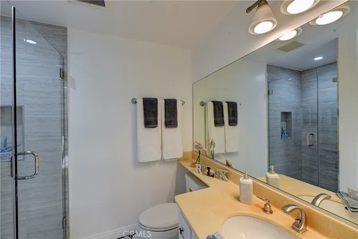 Downstairs bath has a beautifully remodeled glass enclosed shower.