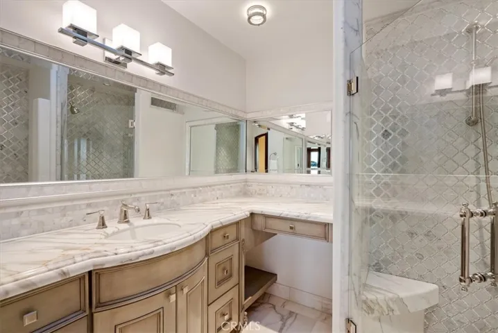 The guest bath is bathed in marble finishes.