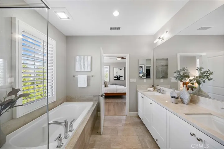 Master suite bath with double vanities, glass walk-in shower, soaking tub & walk-in closet