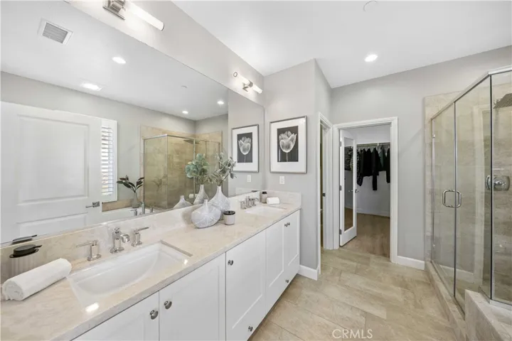 Master suite bath with double vanities, glass walk-in shower, soaking tub & walk-in closet