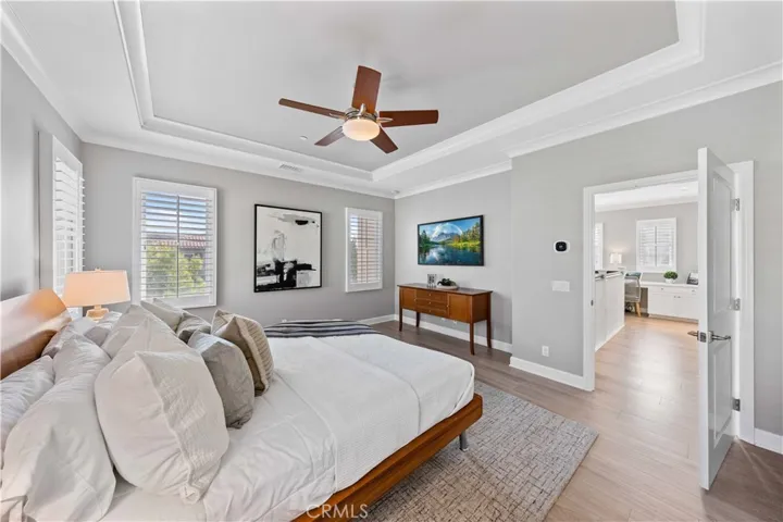 Master suite with coffered ceiling, ceiling fan, hardwood flooring and nature lighting