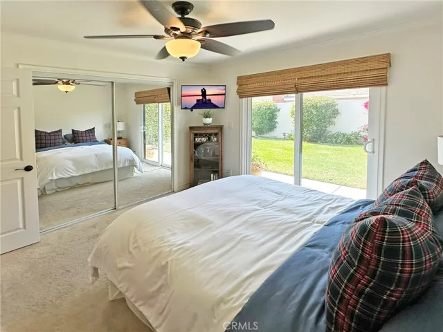 Mirrored glass doors for spacious closet with closet organizers, sliding door to backyard area with fountain, and on suite bath with tiled shower highlight wonderful primary suite